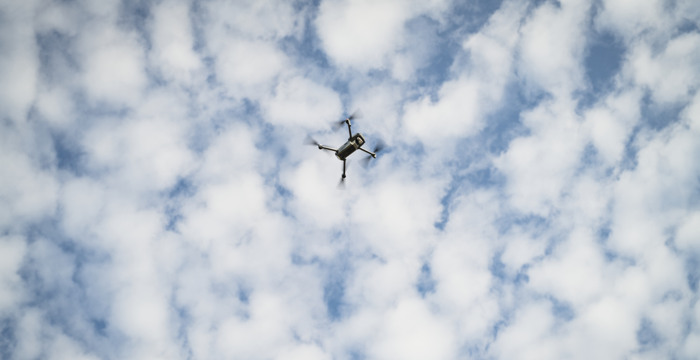 Flygande drönare mot molnig himmel.
