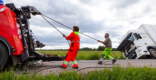 Bärgare drar upp lastbil som kört i diket.
