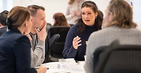 Kursdeltagare i samtal runt bord.